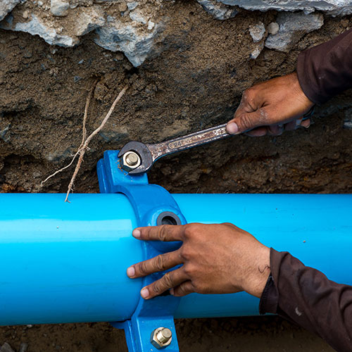 Person Working On In Ground Pipes Person Working On In Ground Pipes